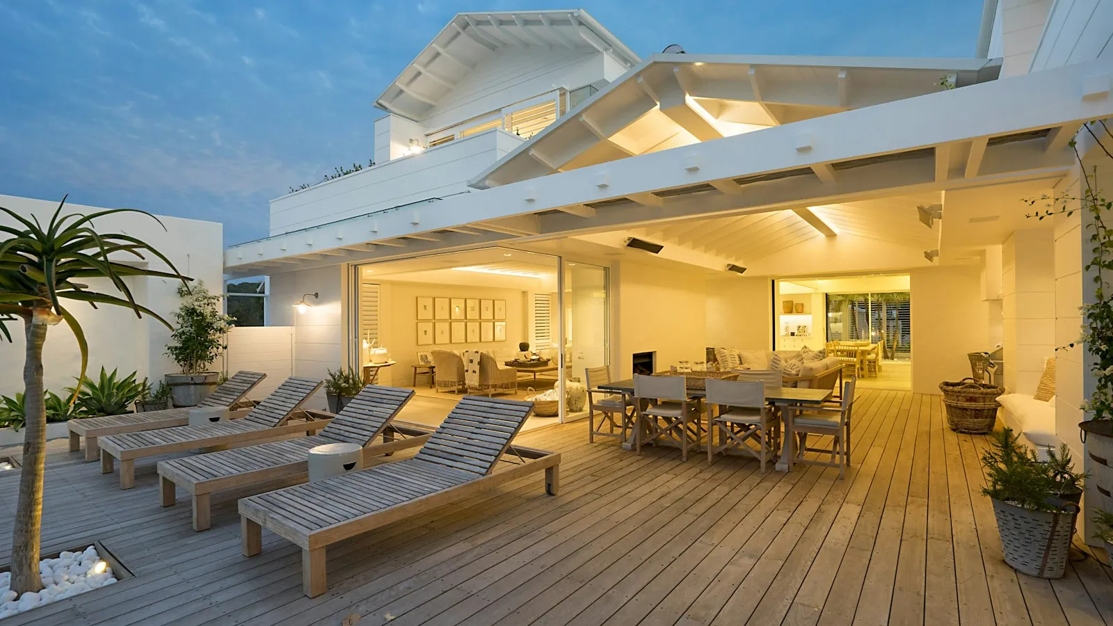 Wood deck with lounge seating at a white coastal Florida home