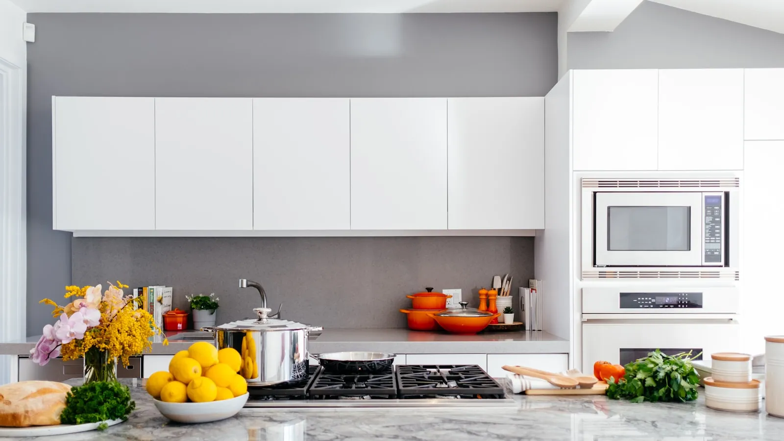 Bright remodeled kitchen with white cabinets, gray quartz counters, and a gas cooktop