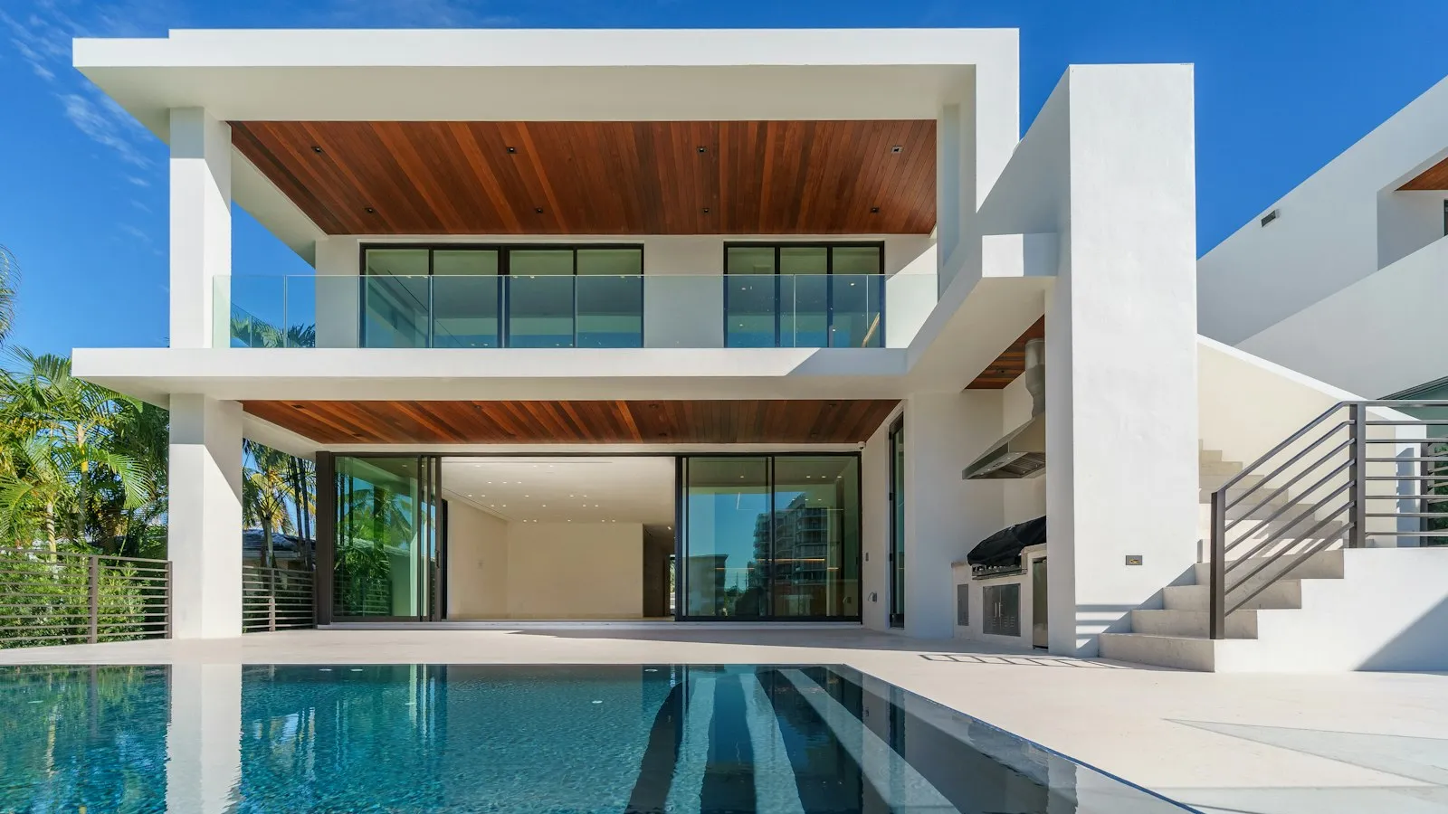 Pool and equipment area at a modern Florida home with palm trees